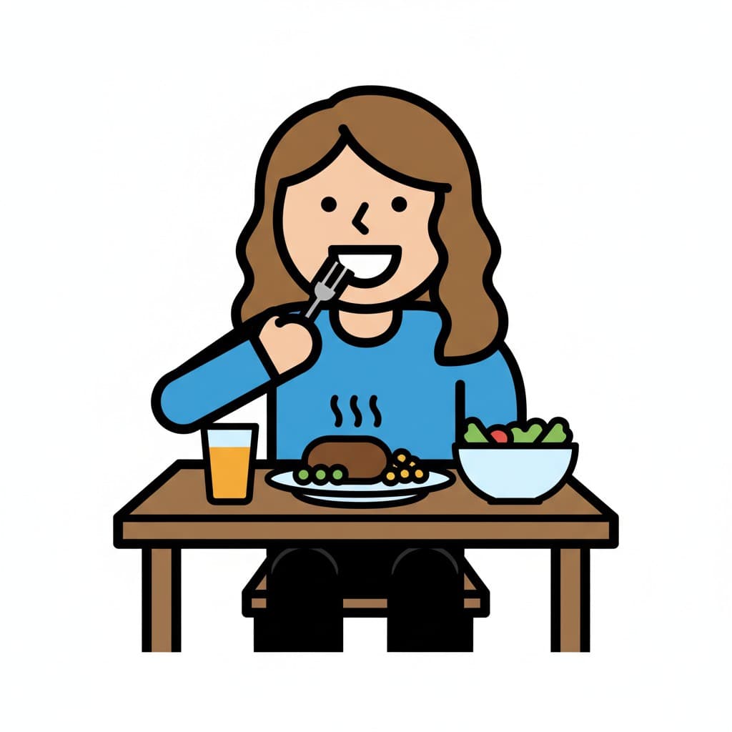 A person sitting at a table, eating dinner. On the table is a plate of food, a glass of juice, and a bowl of salad.